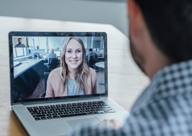 Man on laptop video calling a professional woman